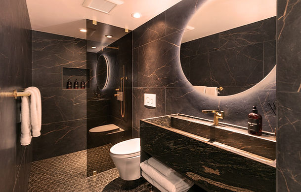 Dark hallway bathroom with gold fixtures